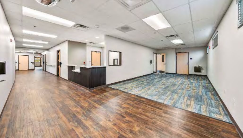 A clinic wing at 2166 with a reception desk and exam room doors.