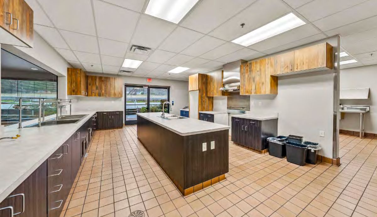 The commercial kitchen at 2166 with a center island and wood cabinets.